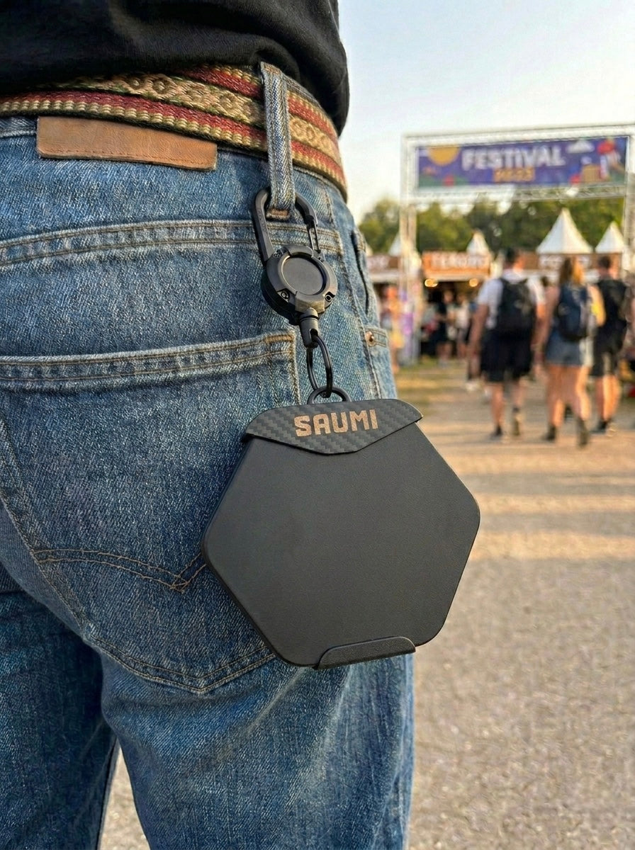 Black protective and transport case for SAUMI the drinking timer hanging from trousers on a person at a festival