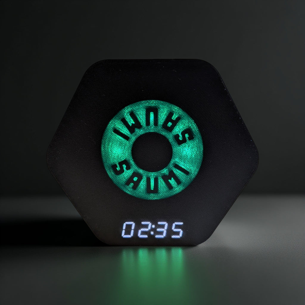 SAUMI the drinking timer in a frontal view. The green LEDs are lighting up and the white display shows 2:35 seconds